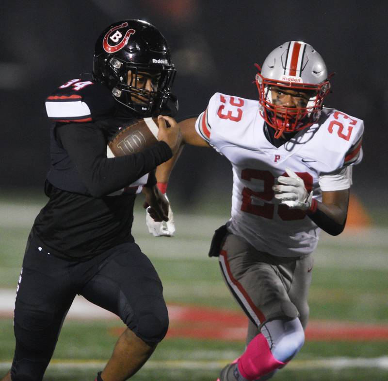 Joe Lewnard/jlewnard@dailyherald.com
Barrington’s Calvin Jackson carries the ball with Palatine’s Ethan Hunt in pursuit during Friday’s game at Barrington.