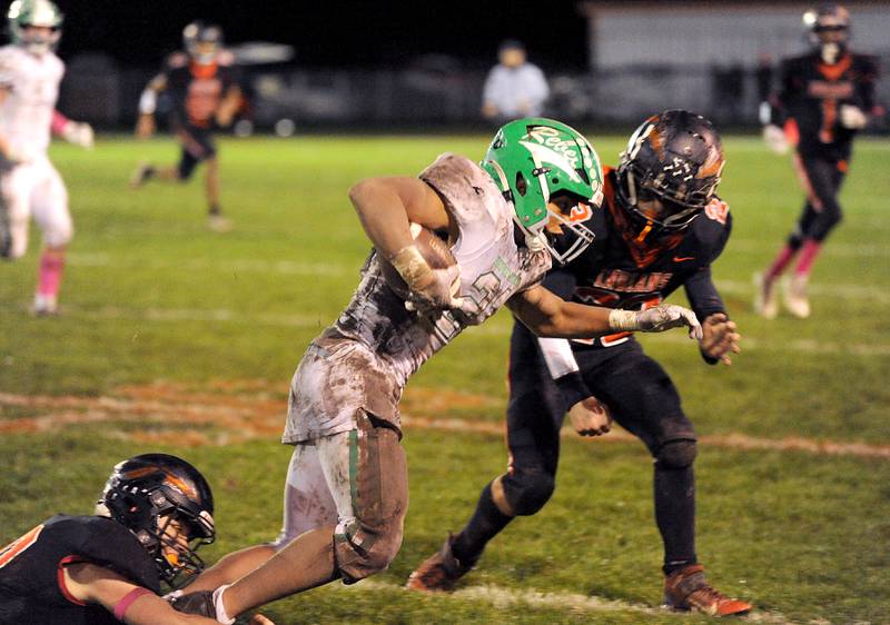 Ridgewood running back Karolina Starczynski (21) splits two Sandwich defenders for a first down during a varsity football game at Sandwich High School on Friday, Oct. 27, 2023.