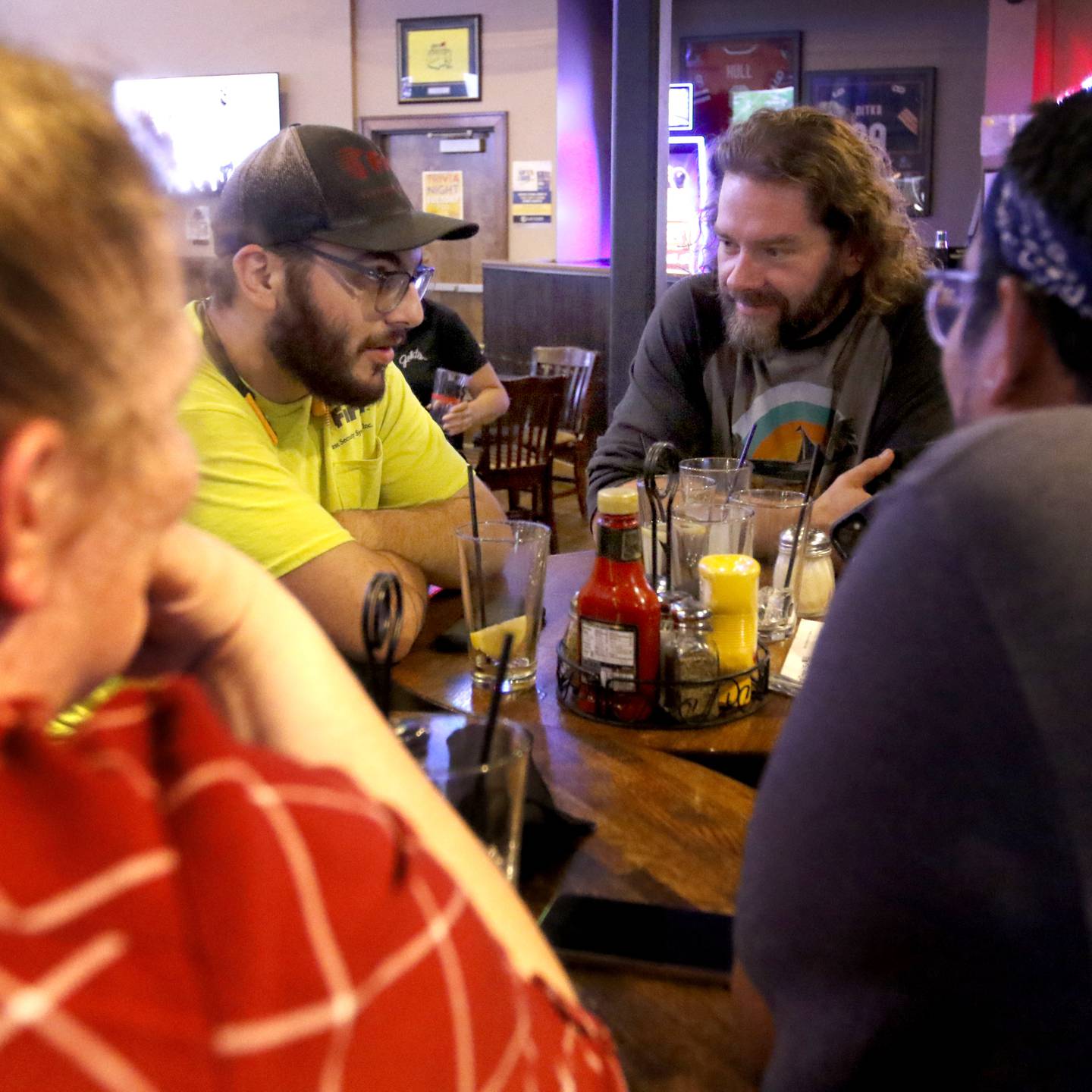 Justin Triplett, (second from right ) Joshua Zapata, (right) Stephanie Zapata (left) and James Lamping, (second from left) from the Phoenix, a recovery nonprofit, discuss their answer to a trivia question on Tuesday, Oct. 8, 2024, during a trivia night at Galati's Hideaway Restaurant in Cary. The recovery nonprofit takes people in recovery on outings such as hiking, bike riding, rock wall climbing, and trivia nights.