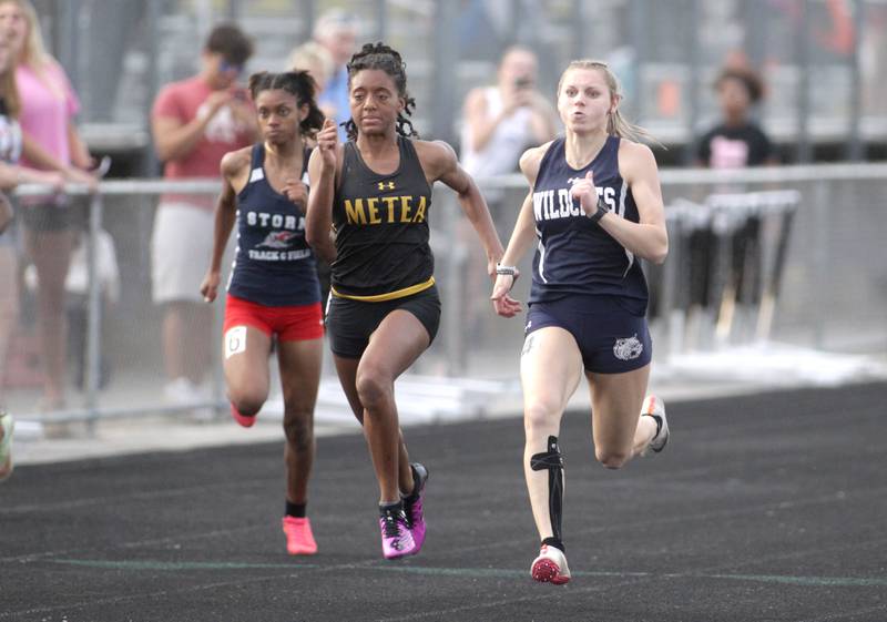 West Chicago’s Kali Waller (right) competes in the final section of the 100-meter dash during the Class 3A Metea Valley girls track and field sectional on Thursday, May 11, 2023.