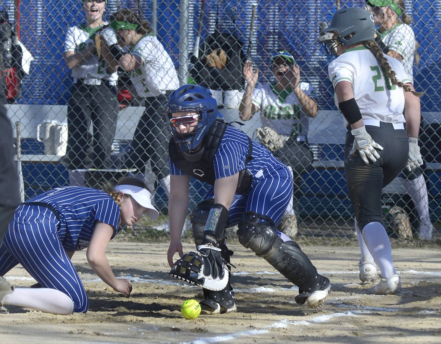 Newark third baseman Gwen Friestad and catcher Danica Peshia work to track down a throw to the plate as Seneca’s Tessa Krull heads to the dugout after scoring in the first inning Monday at Newark.