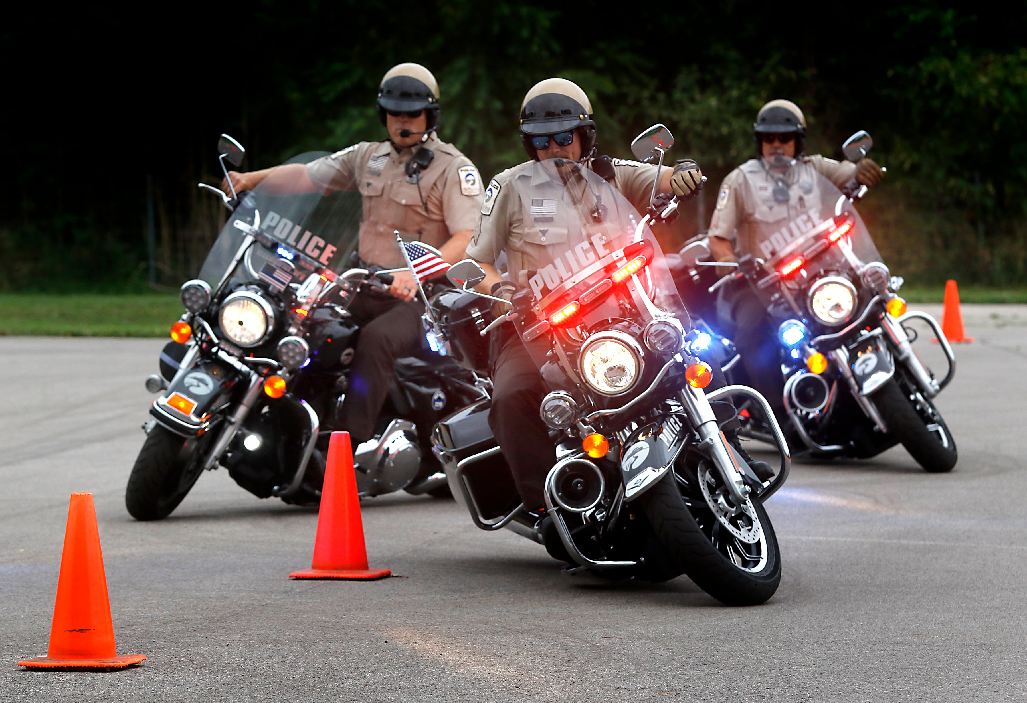 McHenry County Conservation District Police officers ride an obstacle course while  demonstrating their motorcycle skills during a National Night Out event Tuesday, Aug. 6, 2024, at Petersen Park in McHenry. This year's event featured officers from theMcHenry County Sheriff's Department, McHenry County Conservation District Police, and the McHenry Police Department. and the police departments of McHenry along with games, face-painting, K-9 and motorcycle demonstrations, food and family fun.