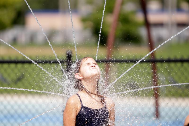 Ten-year-old Emily Gillette of Brookfield plays in the water at the Gordon Park Splash Pad in La Grange as temperatures hit the 90s on Friday, July 28, 2023.
