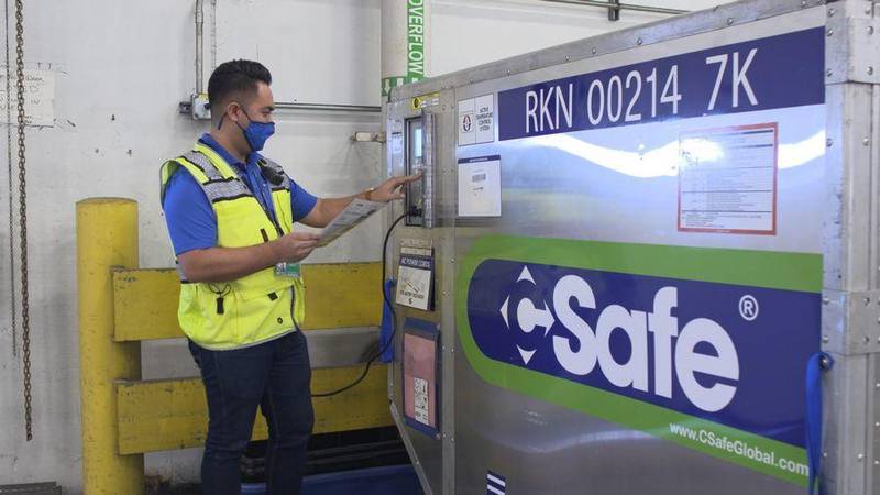 A United Airlines employee checks a cold-storage container. The carrier will be transporting COVID-19 vaccines, which must be kept at extremely cold temperatures.