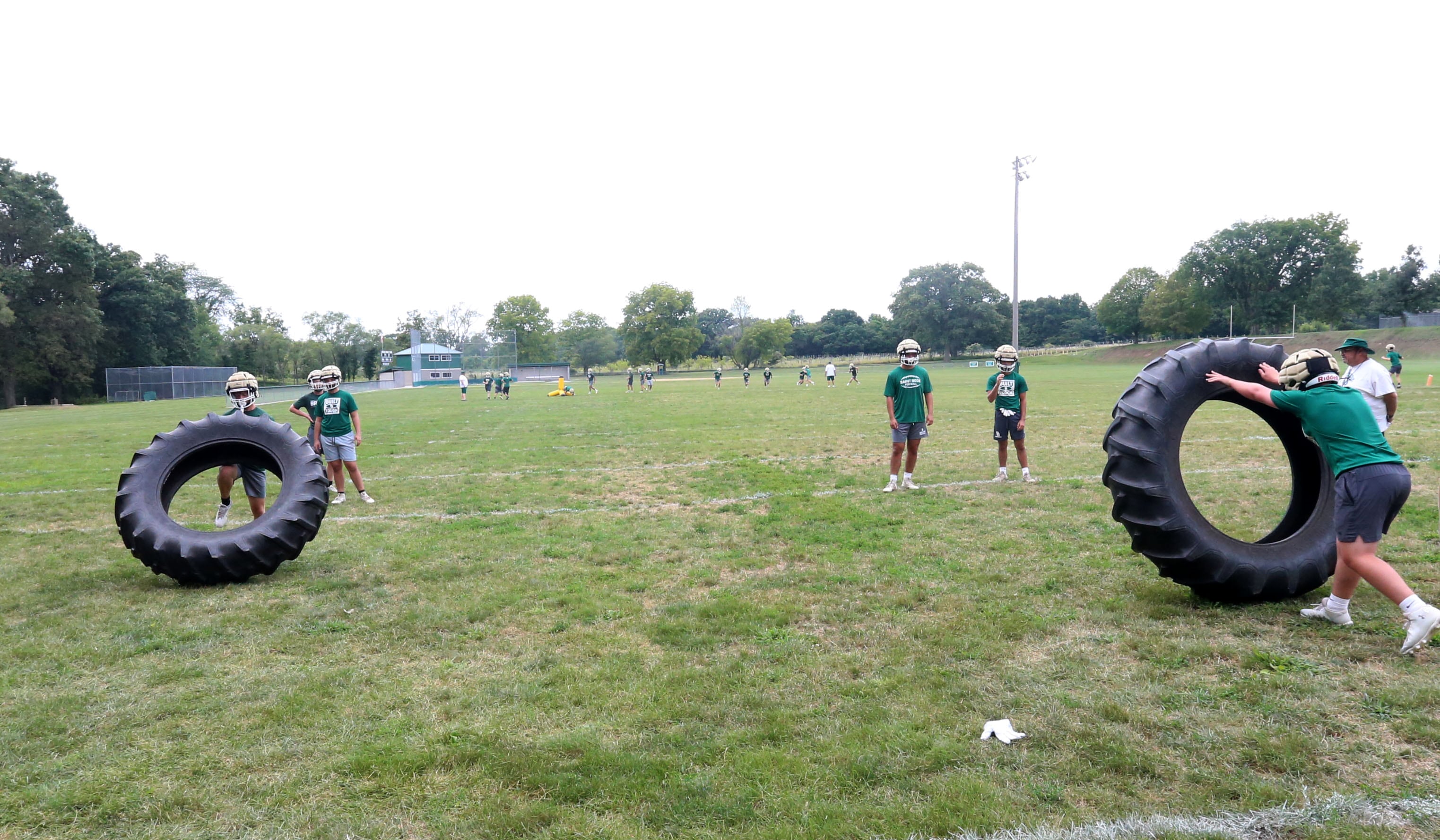 Members of the St. Bede football team flip tractor tires during the first day of football practice on Monday, Aug. 12, 2024 at St. Bede Academy.