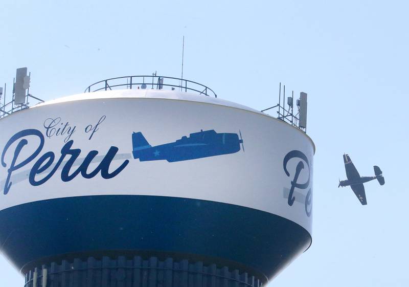 A TBM Avenger aircraft flys over the Peru water tower during the TBM Reunion and Air Show on Friday, May 17, 2024 in Peru.