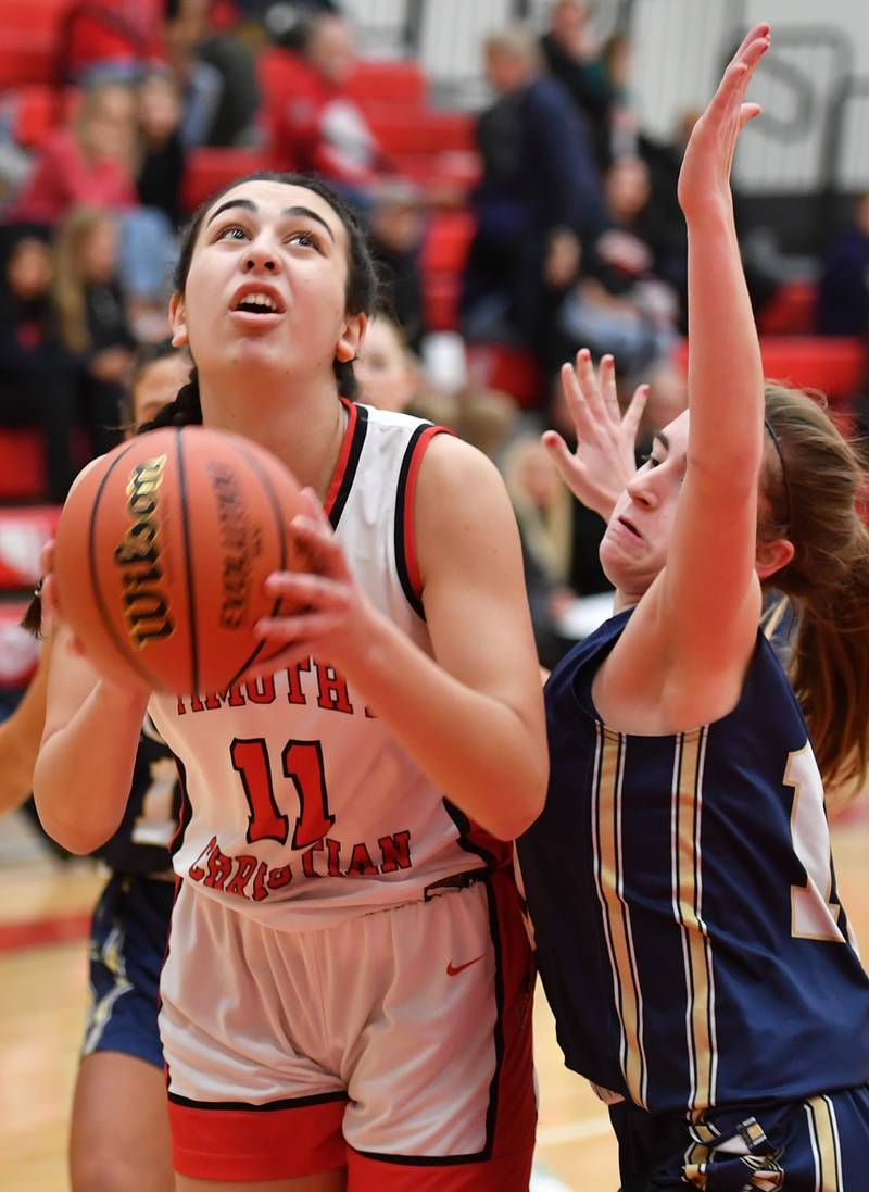 Timothy Christian's Avery Schwarz (11) goes to the basket as IC Catholic'sKelsey McDonough defends during the Class 2A Timothy Christian Regional championship game on Feb. 17, 2023 at Timothy Christian High School in Elmhurst.