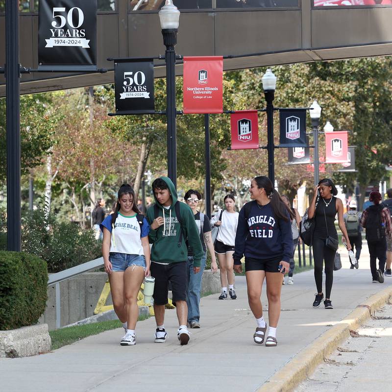 Northern Illinois University students walk down the sidewalk along Normal Road Thursday, Sept. 12, 2024, on campus at NIU in DeKalb.