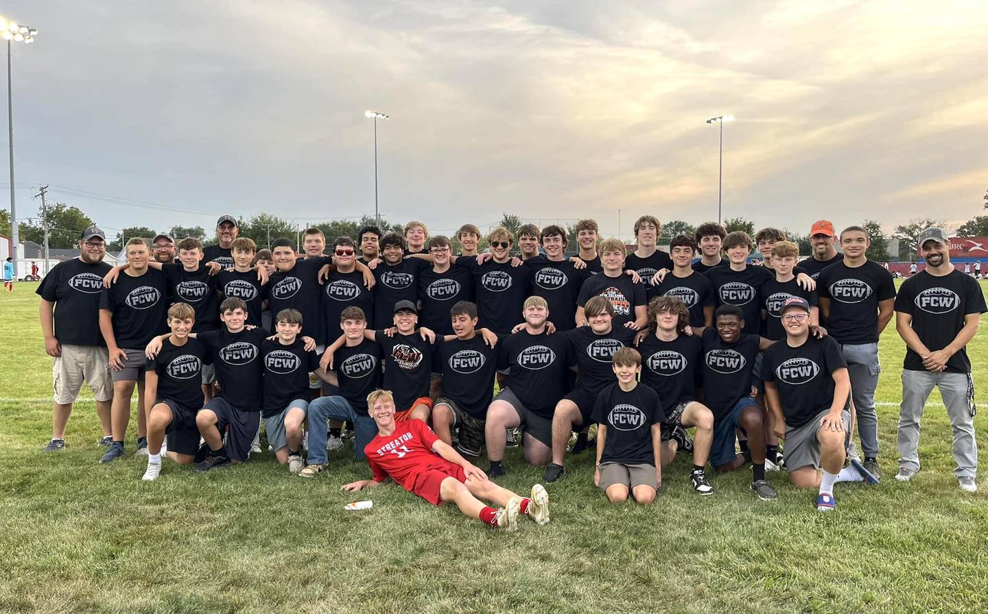 Members of the Flanagan-Cornell/Woodland football program came out to support their placekicker, Streator soccer player Connor Decker (in front, wearing red), at the Bulldogs' match with Plano last Thursday in Streator.