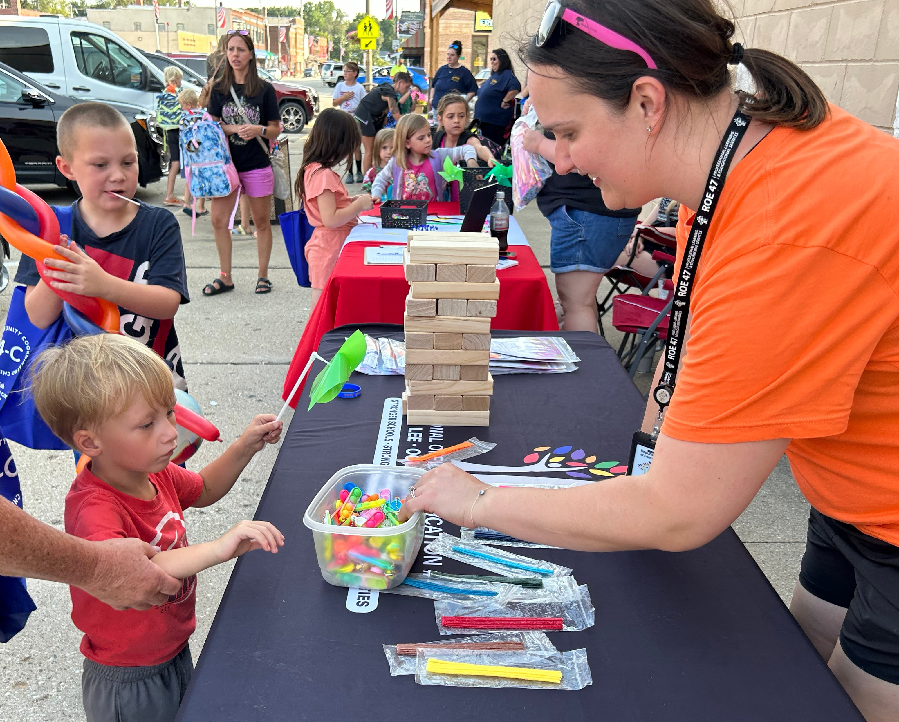 Bentley Hall, 3, of Lyndon, visits with Grace Heimerdinger-Baake, of the Regional Office of Education 47, during Prophetstown's Fourth Friday on Friday, July 26, 2024. The ROE was one of the entities that handed out school supplies and other items during the event.