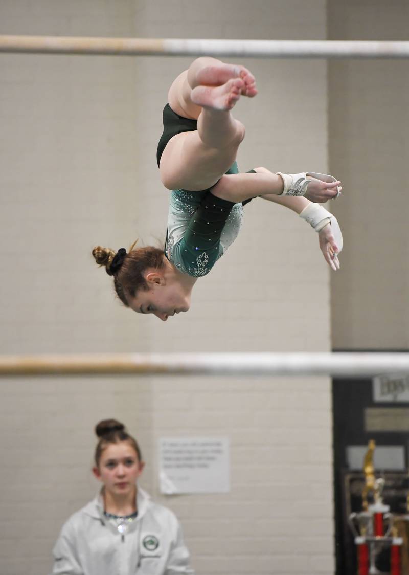 Glenbard West’s Grace Flint on the uneven parallel bars at the Glenbard West girls gymnastics regional meet in Glen Ellyn on Wednesday, January 31, 2024.