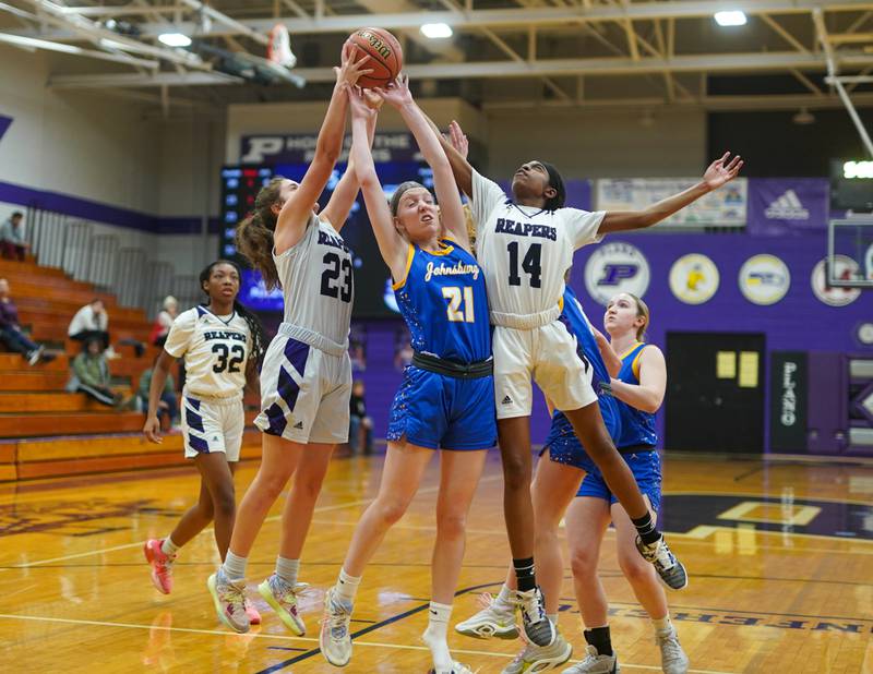 Johnsburg's Carlie Majercik (21) fights for a rebound against Plano's Josie Larson (23) and Luniah Gilford (14) during a basketball game at Plano High School on Tuesday, Jan 30, 2024.