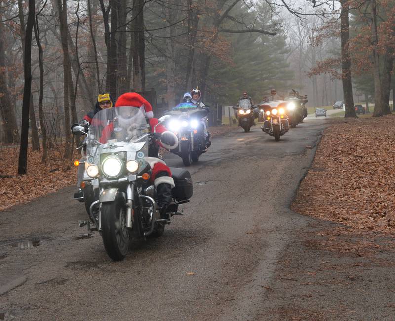 Ben Thielen of Rockford donned a Santa suit when he rode his motorcycle to Lowden State Park on Saturday, Dec. 23, 2023. for a fundraiser for Sarah Wright. Wright has been camping at state parks for several months as she searches for rental property that will allow pets. Thielen is a member of the  Kinsman Redeemers, a Rockford motorcycle club.