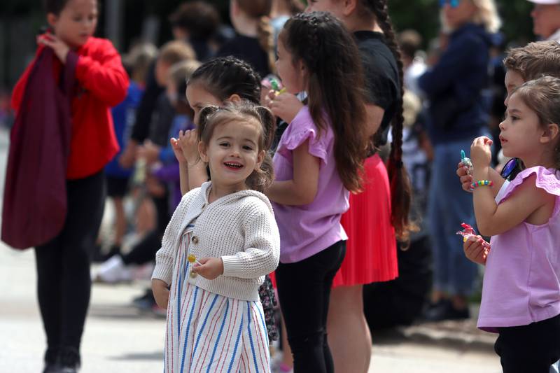 Eliana Leachman, 2, of Woodstock enjoys gathering candy with others as part of the Huntley Memorial Day parade and observance Monday.