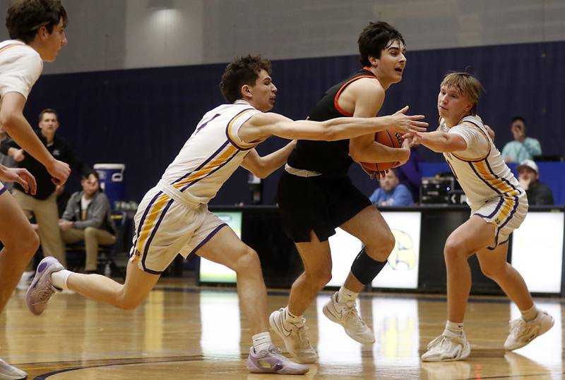 McHenry's Dylan Hurckes is found as he drives the lane between Hononegah's Lucas Touvannas (left) and Cole Warren (right) during the IHSA Class 4A Guilford Boys Basketball Sectional semifinal game on Wednesday, Feb. 28, 2024, at Rock Valley College in Rockford.