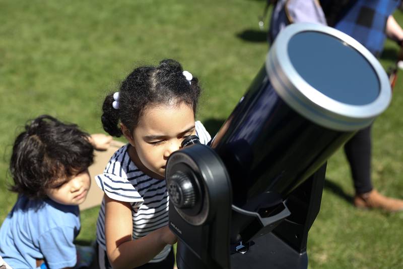 Emile Cervantes, 5, and her little brother Emmanuel, 3, take turns using a special telescope to view the eclipse at the Joliet Junior College solar eclipse viewing event on Monday, April 8, 2024 in Joliet.