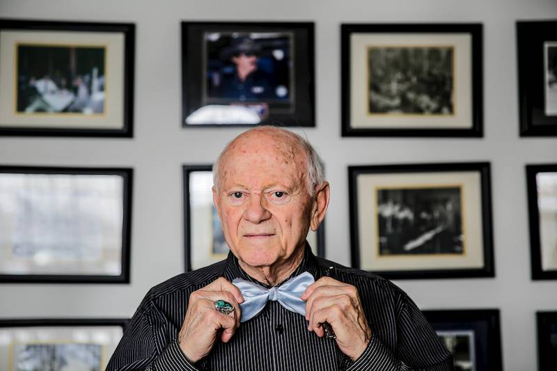 Earl D'Amico posed for a picture in March wearing his characteristic bow tie in front of photographs at his home depicting past scenes and entertainers at his D'Amico's 214 nightclub.