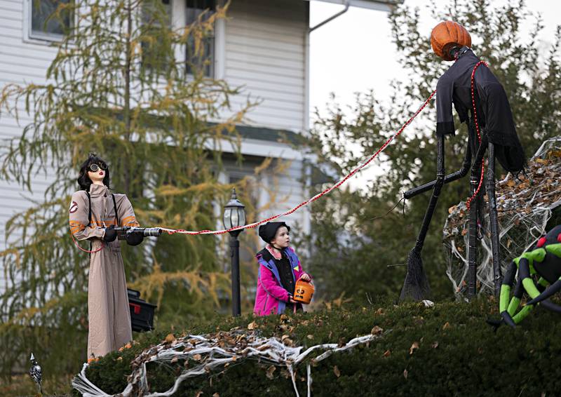 A young trick or treater walks by the Hubbell’s Ghostbusters themed decoration in Dixon Tuesday, Oct. 31, 2023.