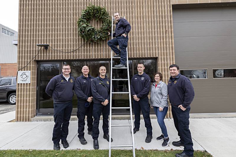 Dixon City and Rural fire departments remind you to keep the wreath red by being extra vigilant regarding holiday fire safety. Pictured: City chief Ryan Buskohl (left), George Markel, Adam Arnould, Cody Schau, Jason Hemmer, Becky Conner and Dustin Dahlstrom, who will become Dixon Rural fire chief in January.