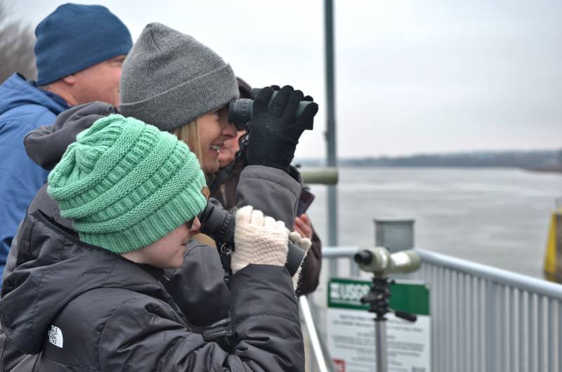 Avery Garner and her mom Beth Garner of Stillman Valley, peek through binoculars to watch the bald eagles at Lock & Dam 13 in Fulton during the 39th annual Bald Eagle Watch.