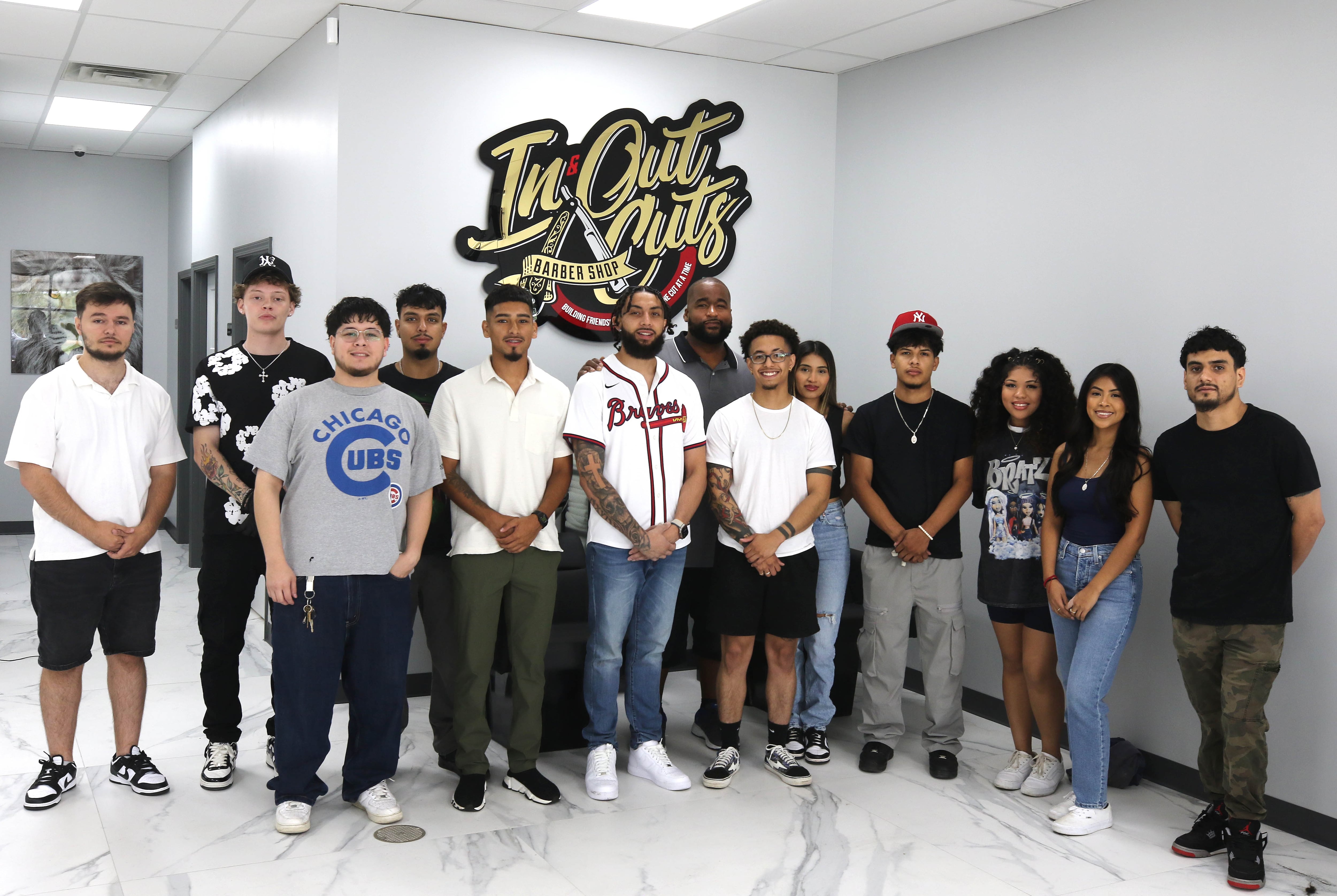 Andre Powell, owner of In & Out Cuts Barbershop, and his staff Friday, Aug 9, 2024,  in their new location at 2331 Sycamore Road in DeKalb.