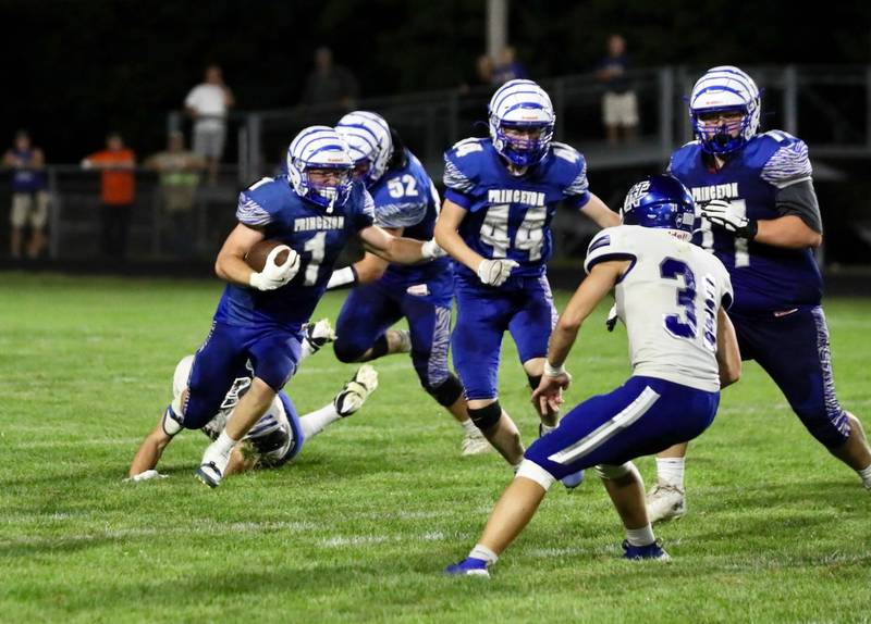 Princeton's Casey Etheridge runs behind the blocks of teammates Alex Winn (44) and Grady Cox (77) against Newman's Friday night at Bryant Field. The Tigers won 28-14.