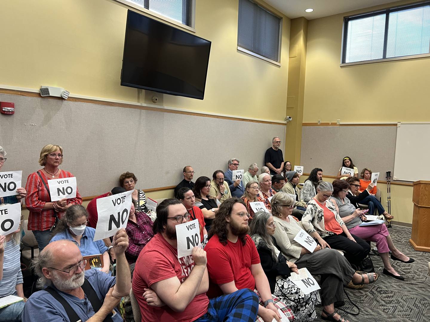 Many of those who attended the DeLalb County Board Law and Justice Committee meeting on May 20, 2024, holds signs that read, "vote no." The public display was in response to a proposed resolution that would have declared DeKalb County a non-sanctuary for asylum seekers during a DeKalb County Board Law and Justice Committee meeting at the Legislative Center in Sycamore on May 20, 2024. The resolution failed to garner enough committee votes to send it to the DeKalb County Board for approval.