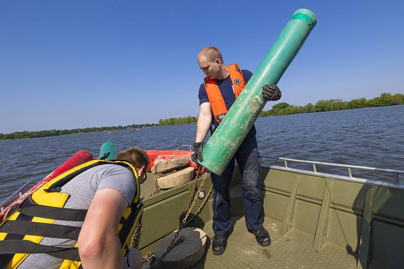 Rock Falls firefighter Dylan Scudder hoists a buoy for placement  Wednesday, May 15, 2024. The local fire departments took over the dropping of the buoys in the Rock River from the IDNR several years ago.