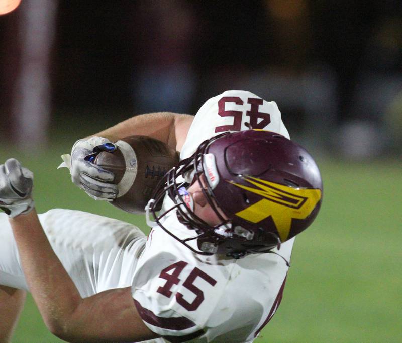 Richmond Burton’s Riley Shea gets upended while running the ball in varsity football at Rod Poppe Field on the campus of Marengo High School in Marengo on Friday, Oct. 18, 2024.