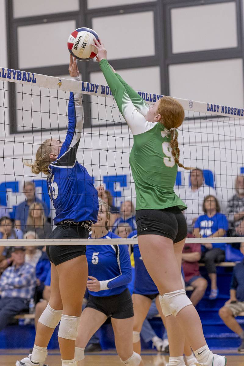 Newark's Taylor Jeffers and Brooklyn Sheedy of Seneca make simultaneous contact with the ball at the center of the net during the match at Newark Community High School on September 9, 2024.