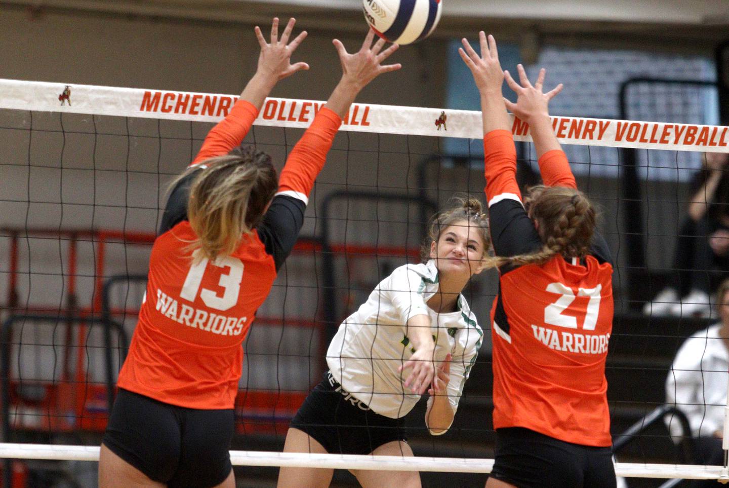 Crystal Lake South’s Bobbi Wire, center, sends the ball over the net in varsity volleyball at McHenry Tuesday night.