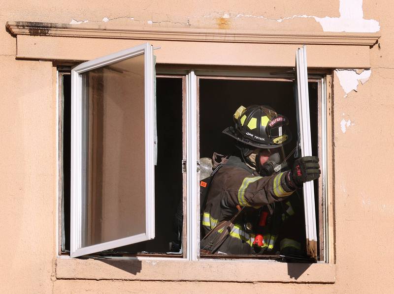 A firefighter opens a window to vent smoke at the site of a structure fire Friday, Sept. 1, 2023, in the building that once housed Fanatico Italian restaurant at 1215 Blackhawk Road in DeKalb.