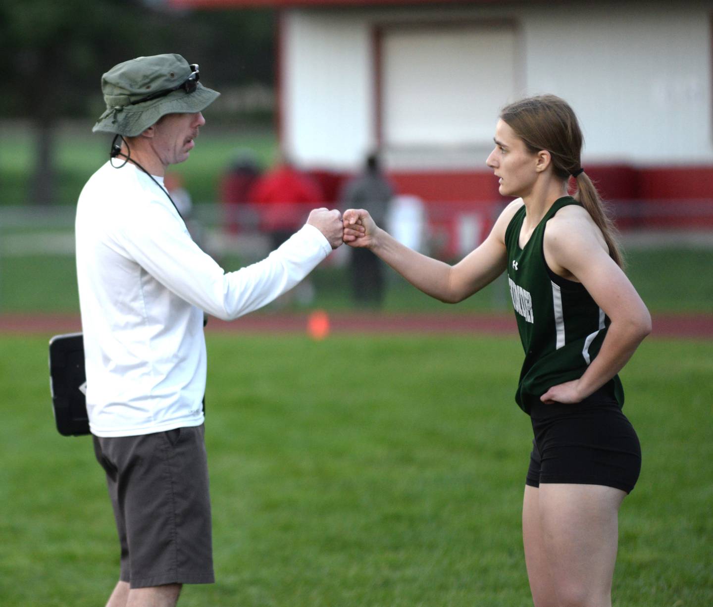 West Carroll's Emma Randecker gets a fist bump from coach Chris McDermott after winning the 200 meters at the 1A Oregon Sectional on Friday. May 10, 2024. Randecker won the 100, 200, and 400 to qualify for the state meet at Eastern Illinois University in Charleston. Randecker, a junior, said she was hoping to win all three events at the meet.