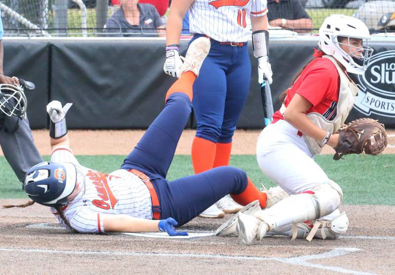 Oswego's Rikka Ludvigson slides safely into home as Mundelein catcher Karina Benes catches the late throw during the Class 4A third place game on Saturday, June 8, 2024 at the Louisville Slugger Sports Complex in Peoria.