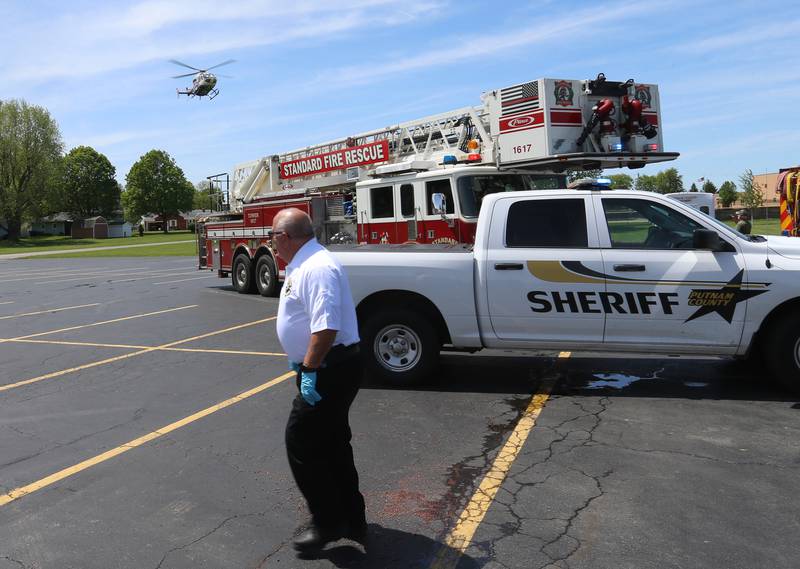 Putnam County EMS director Andrew Jackson watches OSF Lifeflight helicopter land during a "mock prom" scene through the Putnam County Corner's Awareness Program on Friday, May 3, 2024 at Putnam County High School.  Putnam County Fire and EMS units, PC Sheriff, and OSF Lifeflight crew conducted a drill crash scene. The school's prom is Saturday. The program helps students make good choices on prom night.