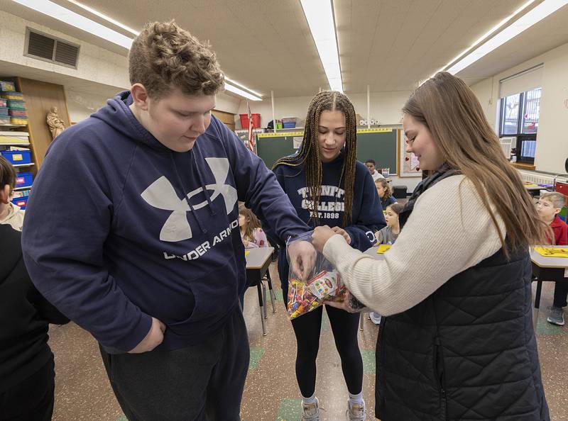 Brady Zeller-Rosinski and Aubrey Devine, both 8th graders at St. Mary’s School in Dixon, receive treats from Dana Merriman, Ag in the Classroom instructor, Thursday, Feb. 1, 2024 in Dixon. Local professionals were brought in for fun and education with the students in celebration of Catholic Schools Week.