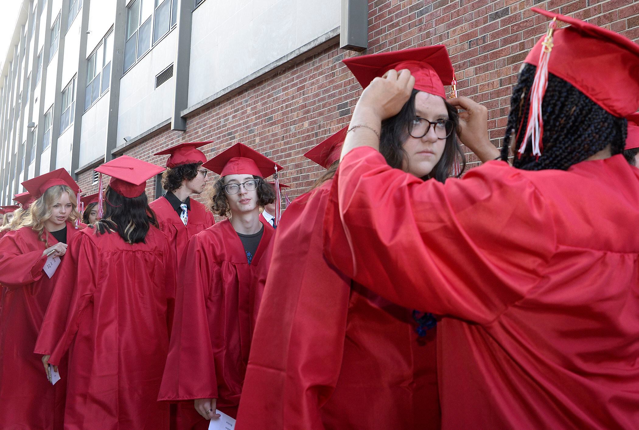 Graduate Kylin Buckingham receives some help with the placement of her cap from fellow classmate Mercedez Bruce prior to the graduation ceremony Friday, May 26, 2023, at Ottawa High School.