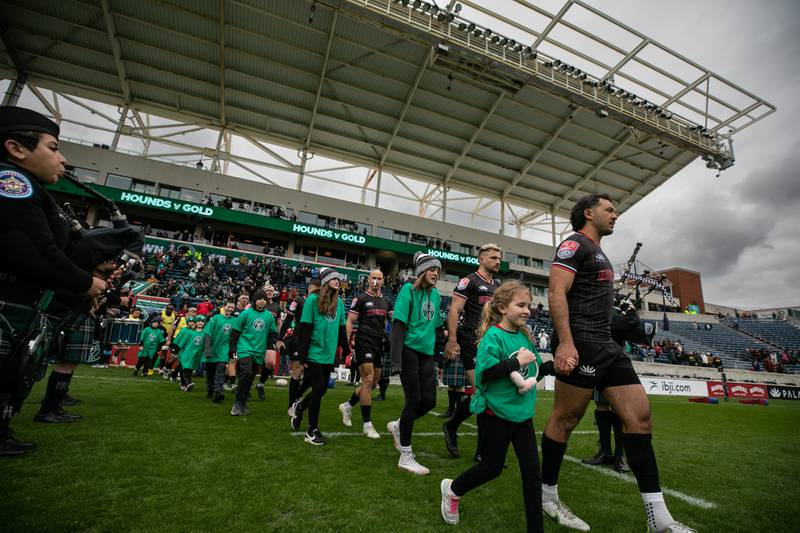 Chicago Hounds rugby players step onto the field before the start of their game against NOLA Gold at Seat Geek Stadium in Bridgeview, on Sunday April 23, 2023. A tradition in rugby and soccer, players are escorted onto the field or pitch by a match mascot, usually youth rugby players themselves.
