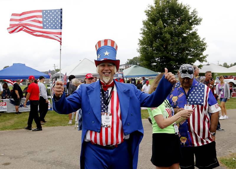 David Dewar of Chicago waves and American flag while dressed as Uncle Sam during the Trump Now-Save the American Dream Rally at the McHenry County Fairgrounds on Sunday Aug. 18, 2024, in Woodstock.