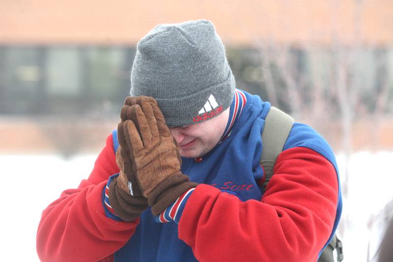 Shaw Local 2008 file photo – Northern Illinois University junior Lee Scott, 21, prays outside Cole Hall after seeing shooting victims being wheeled out of the room in which five of his fellow students were killed and dozens others were injured in a deadly rampage on the