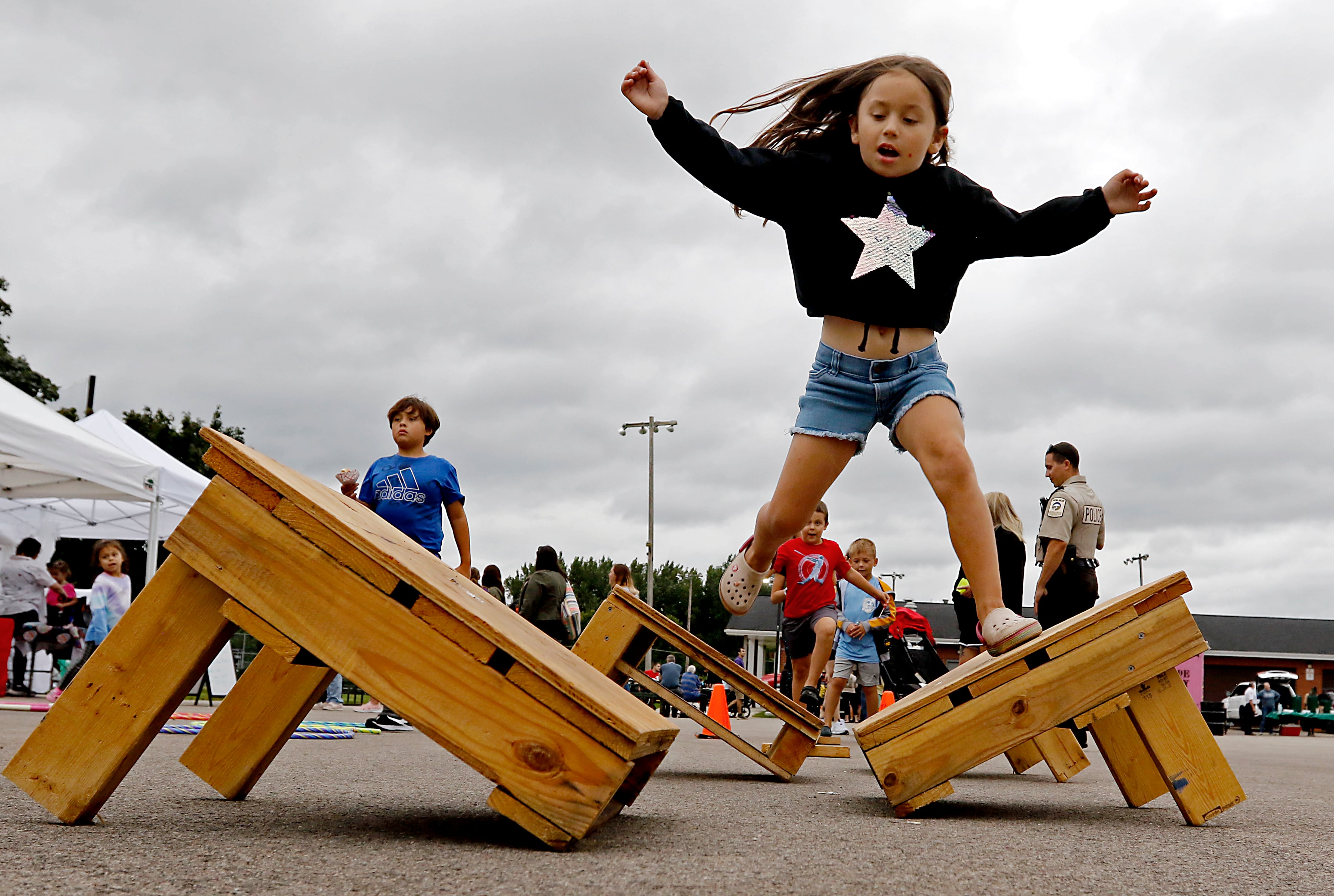 Mabel Van Land, 6, runs through the McHenry Cub Scouts Pack 131 obstacle course during a National Night Out event Tuesday, Aug. 6, 2024, at Petersen Park in McHenry.