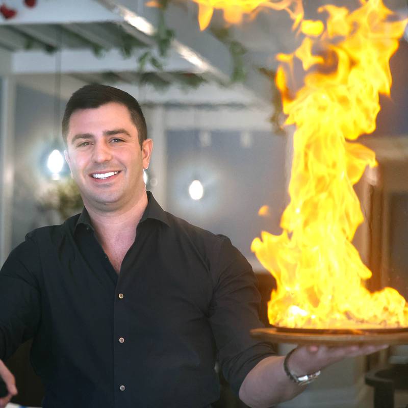 The Flame owner Foti Pappas lights some saganaki Friday, Jan. 19, 2024, in the eatery at 209 East Lincoln Highway in DeKalb. Sagainaki is cheese that is flamed tableside for the patrons.