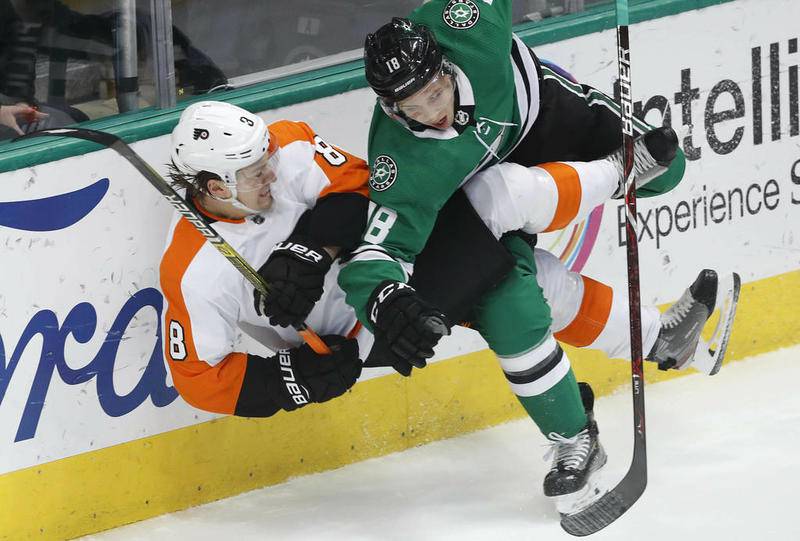 Philadelphia Flyers right wing Ryan Hartman (left) and Dallas Stars center Tyler Pitlick crash into the boards April 2 in Dallas. Hartman, who grew up in West Dundee, was traded Monday to the Stars while he was on a fishing trip in northern Canada. He did not learn of the trade until Tuesday.