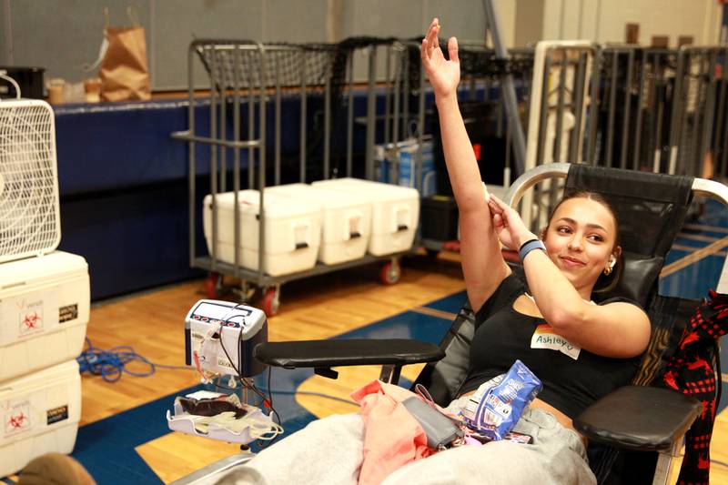 Geneva High School junior Ashley Michelli holds her arm up after donating blood during a visit by Versiti blood donation center as part of the school’s Week of Giving on Wednesday, April 24, 2024.