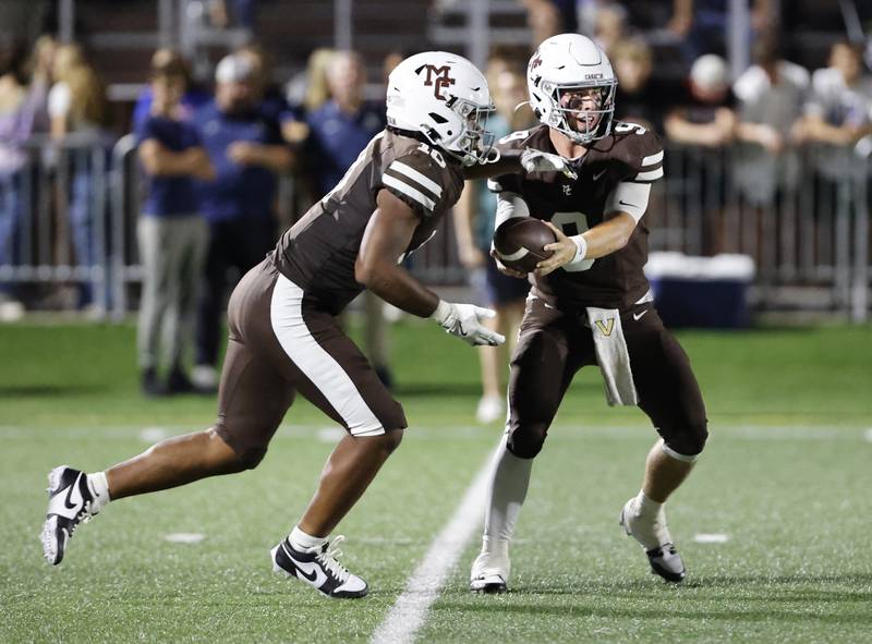 Mt. Carmel's Danyil Taylor Jr. (10) takes a hand off from Jack Elliott (9) during the varsity football game between Nazareth Academy and Mt. Carmel high school on Friday, Sep. 13, 2024 in Chicago.