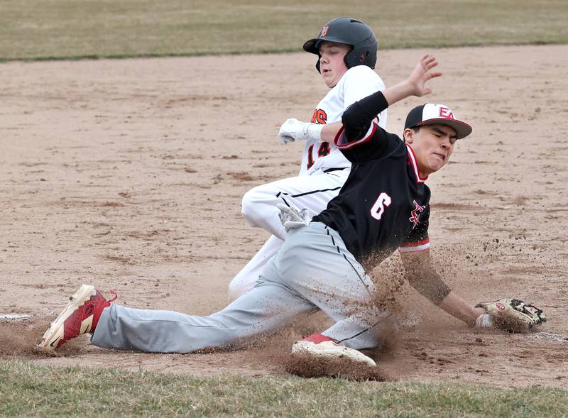 DeKalb’s Brodie Farrell slides safely into third with a stolen base as East Aurora’s Sammy Gonzalez tries to make a play on the throw during their game Wednesday, March 13, 2024, at DeKalb High School.