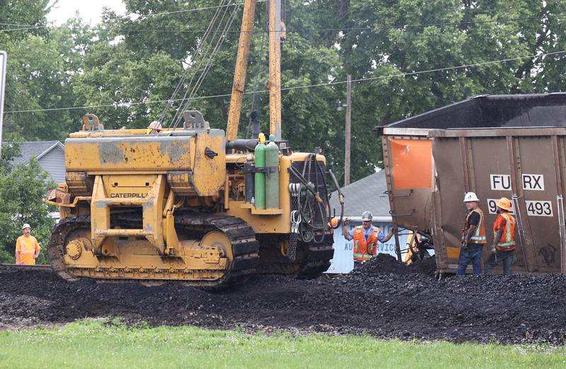 A crane moves into position to finish uprighting a coal car of a BNSF Railway train after it derailed Wednesday, July 10, 2024, near Route 34 on the west side of Somonauk.