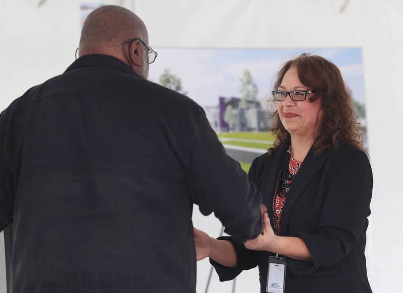 DeKalb School District 428 Superintendent Minerva Garcia-Sanchez (right) welcomes Leroy Mitchell to the podium Thursday, April 11, 2024, during the groundbreaking ceremony for Dr. Leroy A. Mitchell Elementary School. The school will be located at 1240 Normal Road in DeKalb.