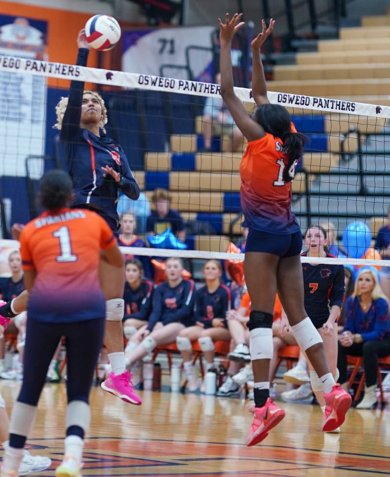 Oswego’s Maya Norlin (18) goes up for a kill against Romeoville's Demi Cole (14) during a volleyball game at Oswego High School on Tuesday, Oct. 17, 2023.