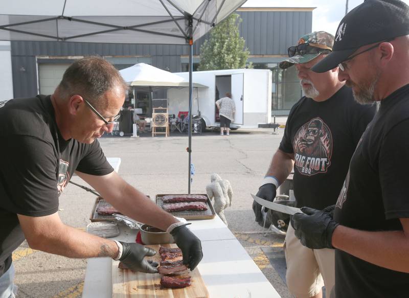 Paul Goluba, Mark Azasa and Dan Durbin all of Streator, cook acks of ribs during the BBQ and Blues festival on Friday, Sept. 13, 2024 downtown La Salle.